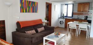 a living room with a couch and a table and a kitchen at VV Apart 10A in Caleta De Fuste