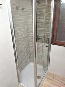 a shower with a glass door in a bathroom at Entre patios y flores in Córdoba