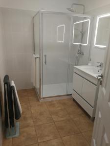 a white bathroom with a shower and a sink at Casa do Imaculado in Funchal