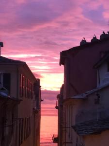 a view of the ocean from between buildings at sunset at Appartement Centre Ville Bastia in Bastia