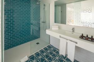 
a bathroom with a sink, mirror, and bathtub at Oasis Lanz Beach Mate in Costa Teguise
