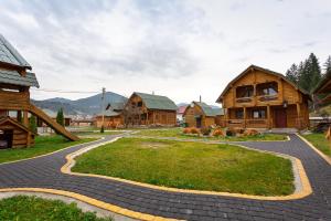 a cobblestone path in front of wooden houses at Gostynnyi Dvir Burkut in Verkhovyna