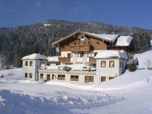 ein großes Haus im Schnee mit Schnee in der Unterkunft Mittersteghof, in Filzmoos