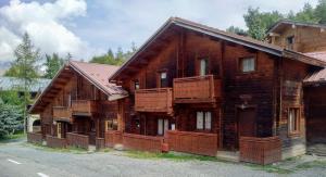 a large wooden house with balconies on a street at Chalet Neve in Les Deux Alpes