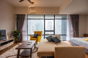 a living room with a couch and a large window at Anggun Residences Luxe in Kuala Lumpur
