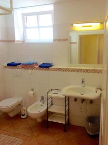 La salle de bains est pourvue d'un lavabo, de toilettes et d'un miroir. dans l'établissement Haus Am Strom 50, à Warnemünde