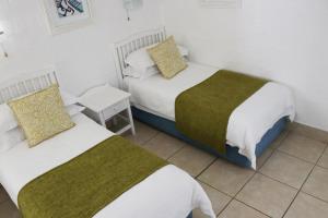 um quarto com duas camas e uma mesa de cabeceira em Kaliva 364 at Club Mykonos in Langebaan em Langebaan