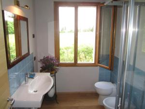baño con lavabo y aseo y ventana en Fara1911 en Fonte