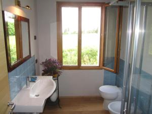 a bathroom with a sink and a toilet and a window at Fara1911 in Fonte