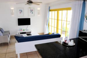 a living room with a blue couch and a tv at Kaliva 364 at Club Mykonos in Langebaan in Langebaan