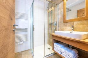 ein Bad mit einem Waschbecken und einer Dusche in der Unterkunft Obergrundhof in Leogang