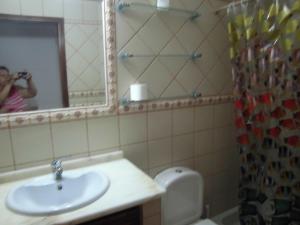 a person taking a picture of a bathroom with a sink at Casa Riqueta Silva in Bordeira