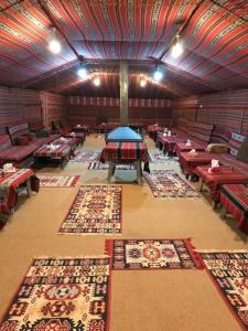a large room with tables and carpets on the floor at Wadi Rum Nature Tours And Camp in Wadi Rum