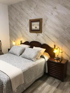 a bedroom with a bed and a table with lamps at La Socorra Suite Adults Only in Fátaga