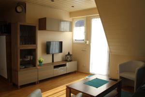 a living room with a table and a tv at Ferienwohnung Auf der Blumenstrasse in Nettetal