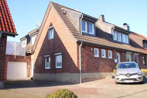 a car parked in front of a brick house at Ferienwohnung Auf der Blumenstrasse in Nettetal