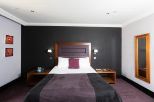 1 dormitorio con 1 cama grande y 2 mesitas de noche en Fletcher's Restaurant Bar & Rooms en Stirling