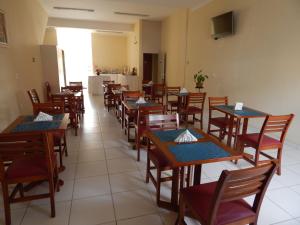 uma sala de jantar com mesas e cadeiras de madeira em Hotel São Judas em Jundiaí