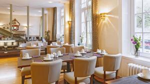 Un comedor con una mesa larga y sillas. en Hotel Fürst Bismarck, en Hamburgo