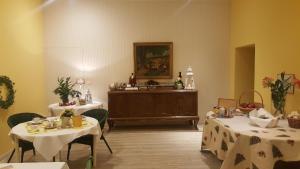ein Zimmer mit zwei Tischen und einem Buffet in einem Zimmer in der Unterkunft Pension Am Holzgraben in Lübbenau