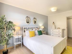 ein Schlafzimmer mit einem großen weißen Bett mit zwei Spiegeln in der Unterkunft Tropical Sun by LovelyStay in Funchal