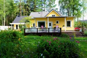 uma casa amarela com cadeiras cor-de-rosa no alpendre em Guesthouse Torppa em Korkeakoski