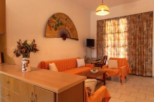 カボスにあるMagdalena Apartmentsのリビングルーム(オレンジ色のソファ、テーブル付)
