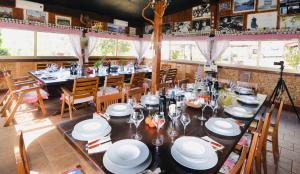 una sala da pranzo con un lungo tavolo e piatti bianchi di Casa Mazzoni a Roccastrada