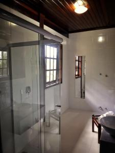 y baño con ducha acristalada y lavamanos. en Pousada Casarão, en Jaraguá do Sul