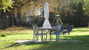 uma mesa com um guarda-sol branco e cadeiras em Ferienhaus Gut Rattelvitz Insel Rügen em Gingst