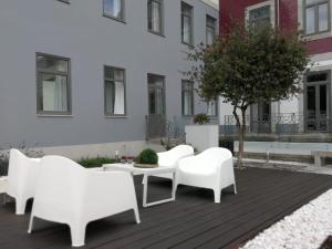 un groupe de chaises blanches et une table sur une terrasse dans l'établissement Porto Downtown Lovers Suites: Bombarda 451, à Porto