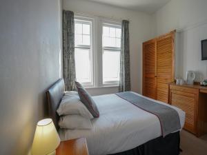 a bedroom with a bed and a window at OYO Shanklin Beach Hotel in Shanklin