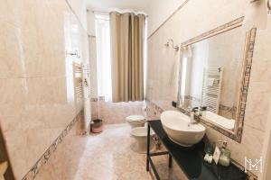 a bathroom with a sink and a toilet and a mirror at Mulberry House in Trani