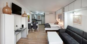 - un salon avec un canapé et une salle à manger dans l'établissement Studio Apartment Theatre View, à Sarajevo