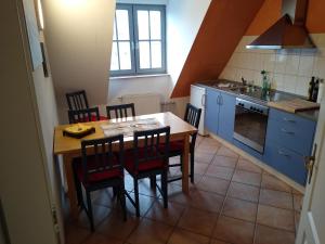 Maisonettewohnung auf 2 Etagen mit zwei Balkonen في بارث: مطبخ مع طاولة وكراسي خشبية في مطبخ