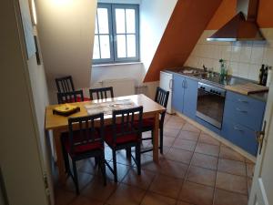 een keuken met een houten tafel en stoelen bij Maisonettewohnung auf 2 Etagen mit zwei Balkonen in Barth