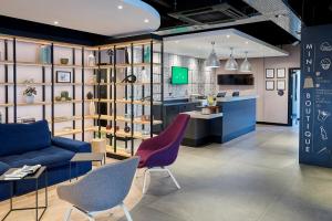 a living room with a blue couch and two chairs at Campanile Hotel - Birmingham in Birmingham