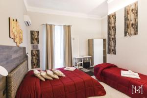 a bedroom with two beds with red comforters at Mulberry House in Trani
