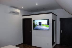 um quarto com uma televisão de ecrã plano na parede em Il Galeone hotel em Stupava