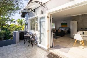 eine offene Tür zu einer Terrasse mit einem Tisch und Stühlen in der Unterkunft Casa Casa - Studio in Durban