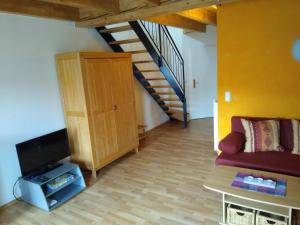 a living room with a couch and a staircase at Maisonettewohnung auf 2 Etagen mit zwei Balkonen in Barth