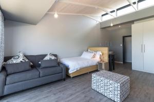 a living room with a couch and a bed at Sky Blue Guest House in Kenton on Sea
