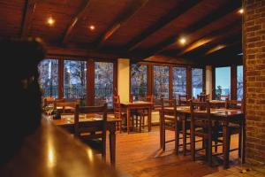 a restaurant with wooden tables and chairs and windows at Il Galeone hotel in Stupava