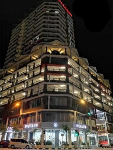a tall building at night with a car parked in front at The Octagon Ipoh - Home Stay in Ipoh