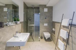 a bathroom with a sink and a shower and a toilet at cosy grey apartments in Freiburg im Breisgau