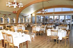a dining room with white tables and chairs at Warrens Village Motel and Self Catering in Clevedon