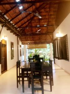 a dining room with a wooden table and chairs at Marari Greenland Homestay in Mararikulam