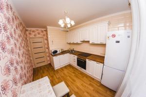 a kitchen with white cabinets and a white refrigerator at ATLANT Apartments 213 in Voronezh