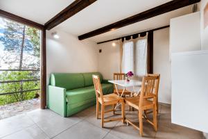 a dining room with a table and a green couch at Ippotur Medieval Resort in Castelnuovo Magra