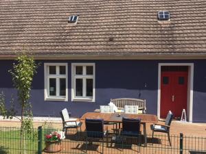 ein blaues Haus mit einem Holztisch und Stühlen in der Unterkunft Ferienhaus Niemtsch in Niemtsch